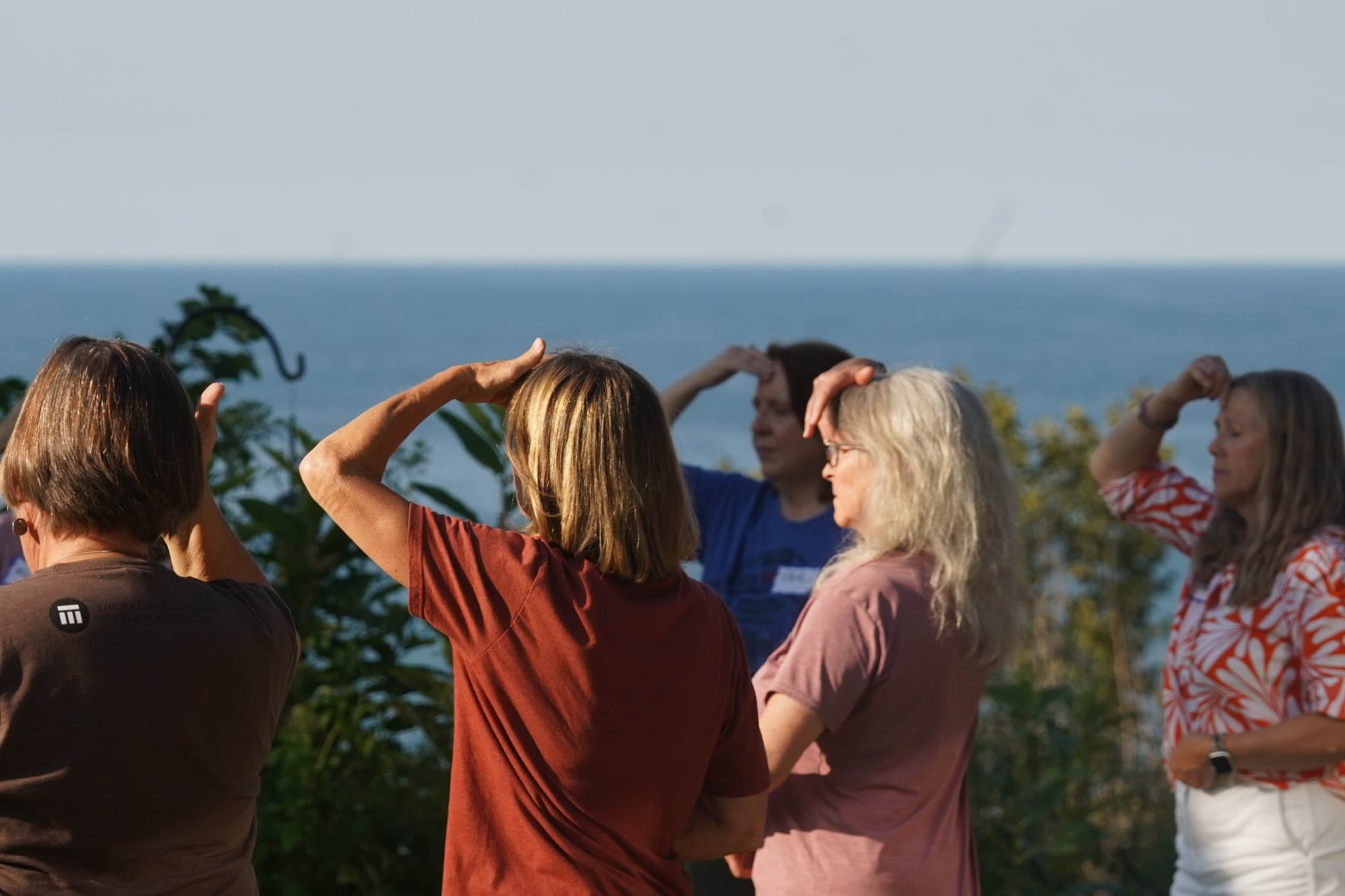 Group stretching together on the lawn with Lake Michigan in the background