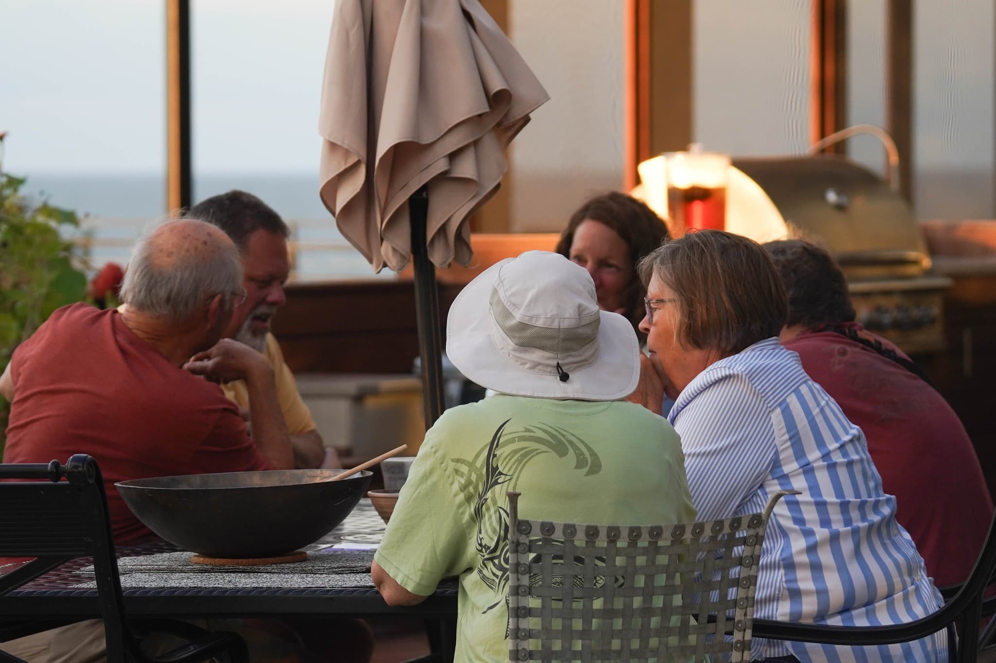 Friends sharing a meal outdoors at golden hour by Lake Michigan